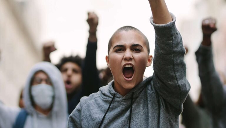 Unclear If Angry-Looking Bald Person A Neo-Nazi Or Leftist Woman